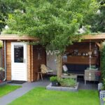 This small log cabin has a flat roof and a veranda